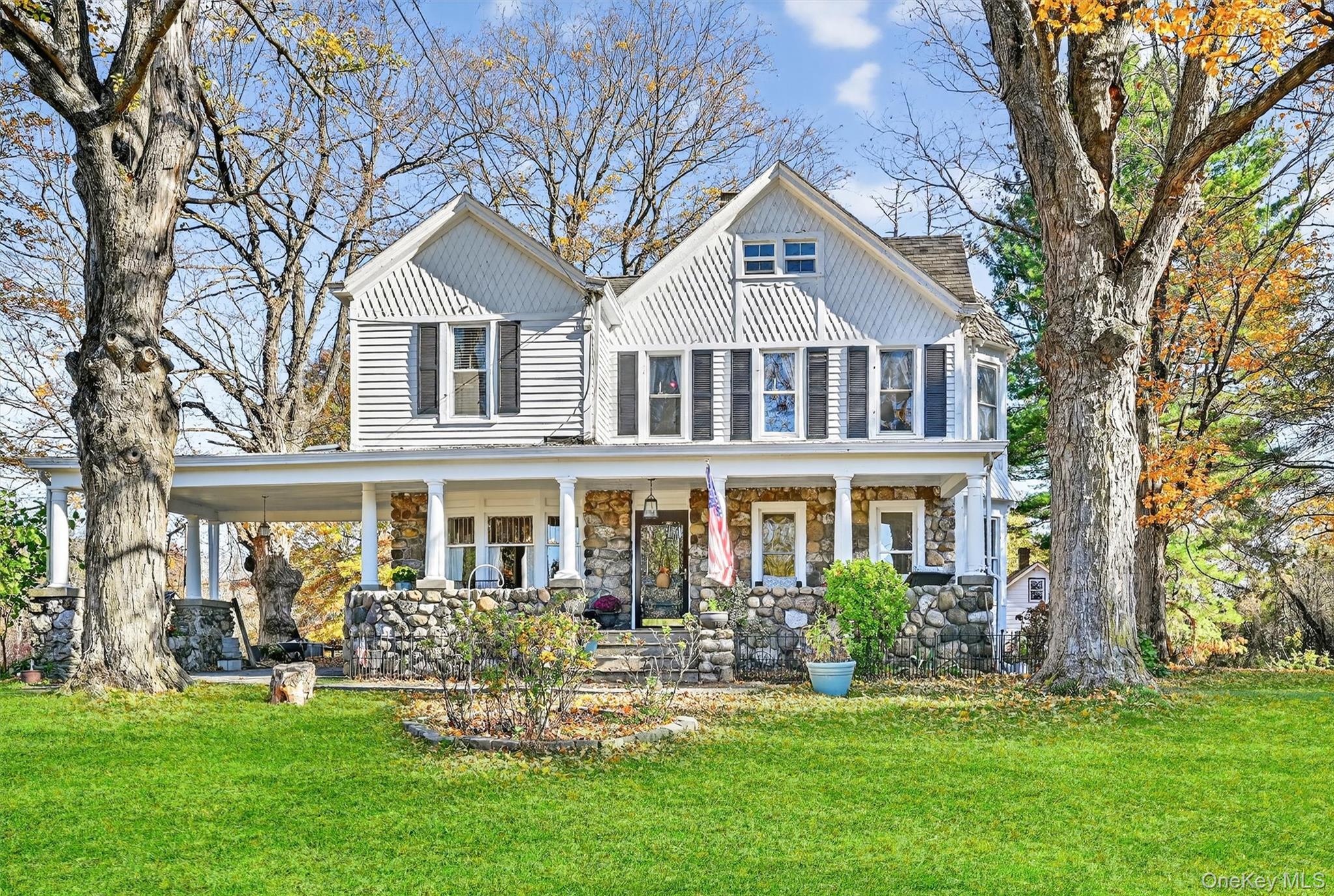 a front view of a house with a garden and trees