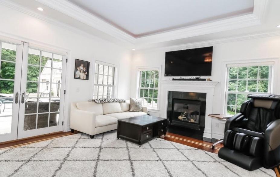 5 Clocks Lane Darien, CT 06820 - Photo 15 of 35 a living room with furniture a flat screen tv and a fireplace