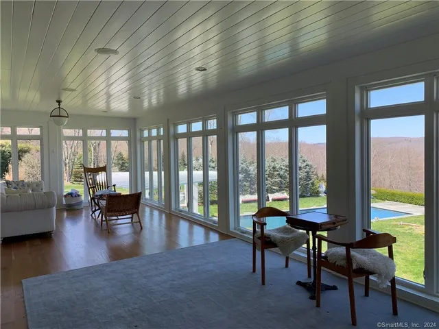 a view of a livingroom with furniture and floor to ceiling window