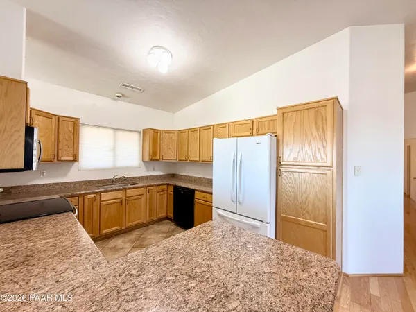 a large kitchen with a refrigerator and a sink