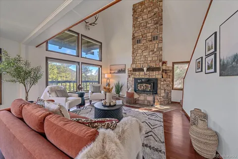 a living room with fireplace furniture and a large window