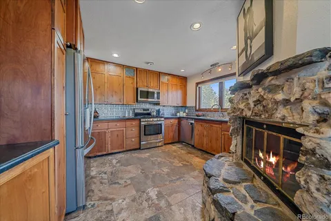 a kitchen with stainless steel appliances wooden cabinets a stove top oven a sink and dishwasher