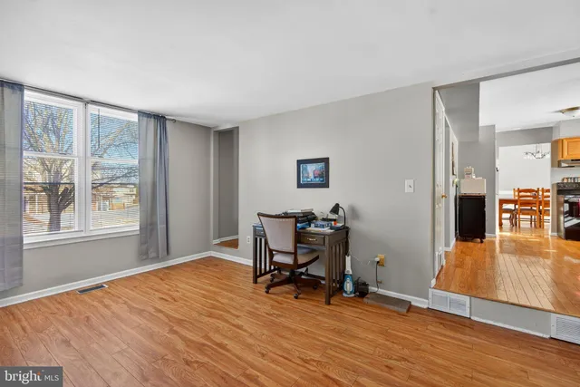 a view of a workspace with wooden floor and a window