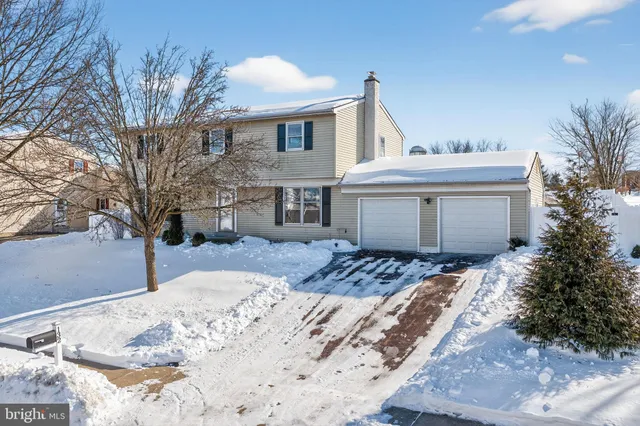a view of a white house with a yard covered in snow