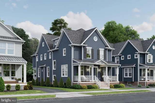a front view of a residential apartment building with a yard and large trees
