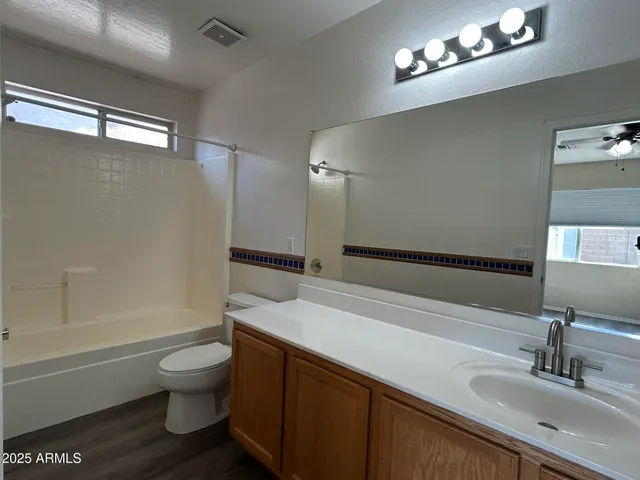 a bathroom with a sink a toilet a mirror and bathtub