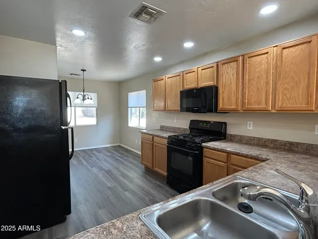 a kitchen with granite countertop a sink stainless steel appliances and cabinets
