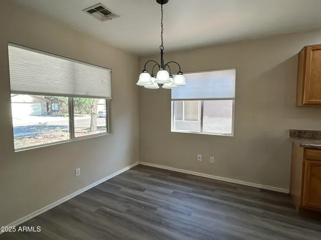 a view of a room with wooden floor chandelier and a window