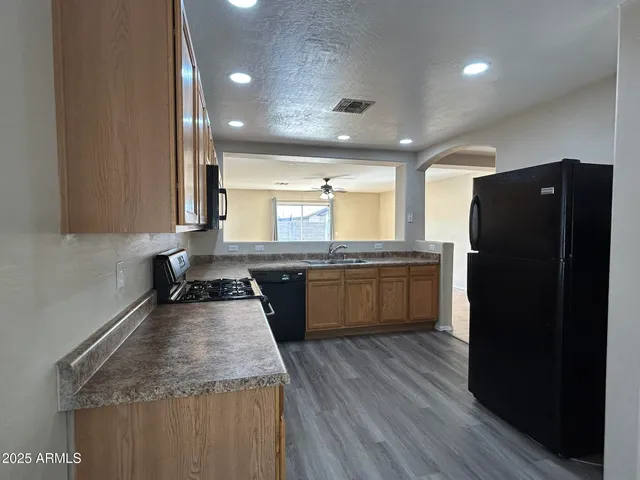 a kitchen with a refrigerator a sink and wooden cabinets
