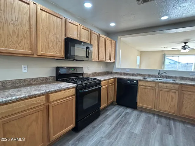 a kitchen with stainless steel appliances granite countertop wooden cabinets and a stove top oven