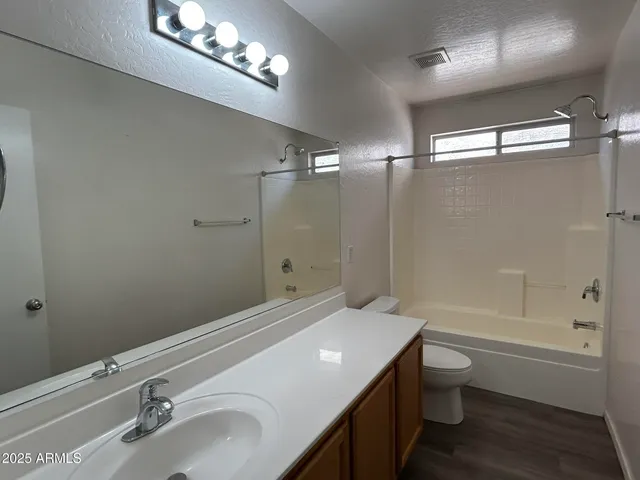 a bathroom with a sink a toilet a mirror and shower