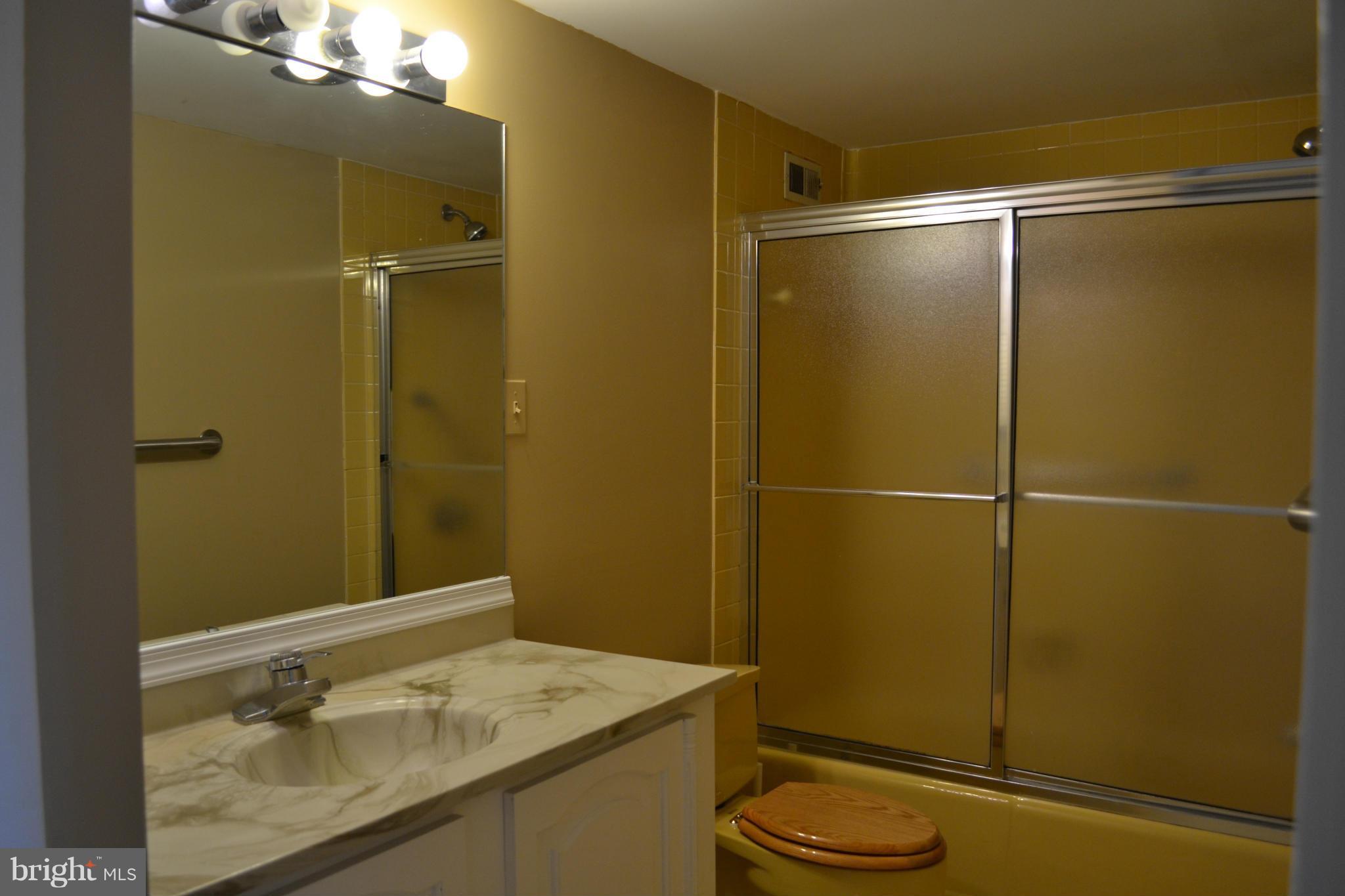 5225 Pooks Hill Road, Unit 204S Bethesda, MD 20814 - Photo 11 of 14 a bathroom with a granite countertop sink toilet and shower