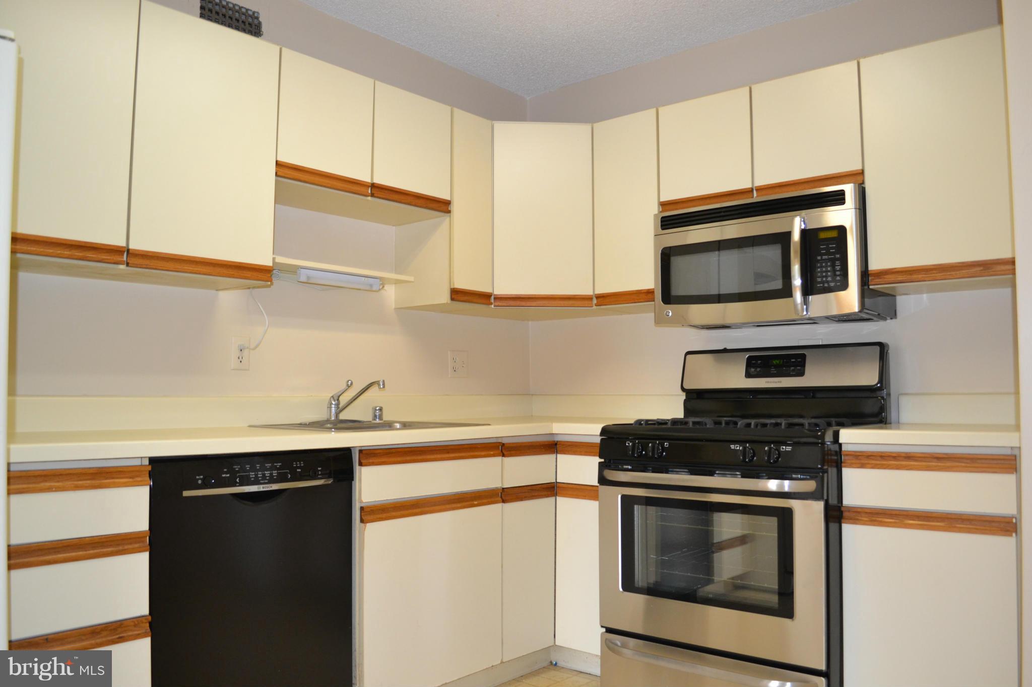 5225 Pooks Hill Road, Unit 204S Bethesda, MD 20814 - Photo 5 of 14 a kitchen with granite countertop cabinets stainless steel appliances and wooden floor