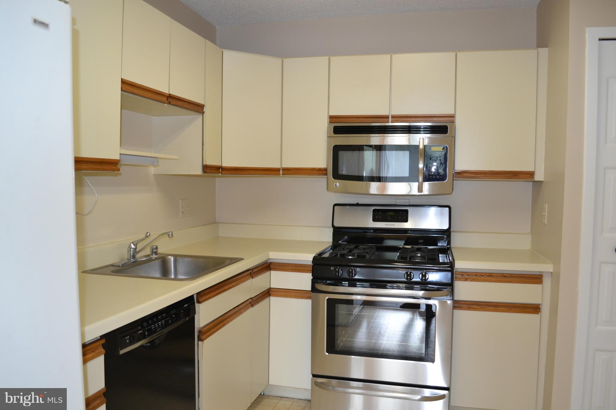 5225 Pooks Hill Road, Unit 204S Bethesda, MD 20814 - Photo 6 of 14 a kitchen with granite countertop a stove and a microwave