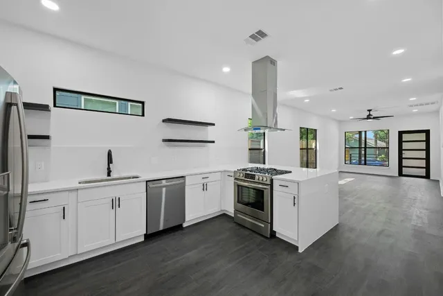 a kitchen with stainless steel appliances and white cabinets