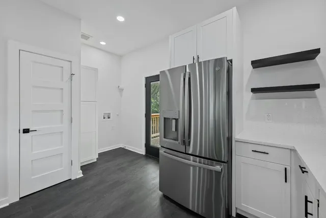 a kitchen with stainless steel appliances a refrigerator and wooden floor