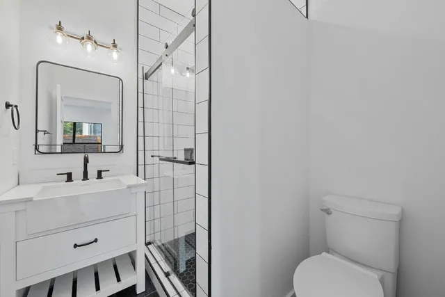 a bathroom with a toilet a sink and mirror