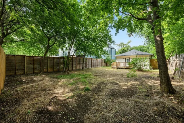 a view of a house with backyard and a tree