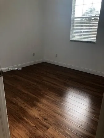 a view of a room with wooden floor and a window