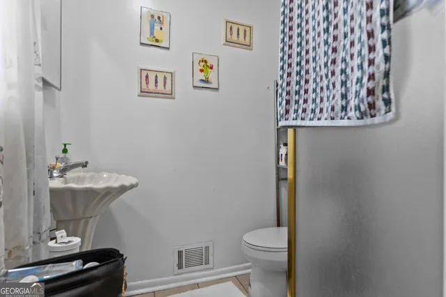 a bathroom with a granite countertop sink and a toilet
