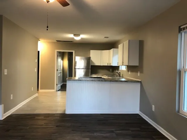 a view of kitchen with microwave and wooden floor