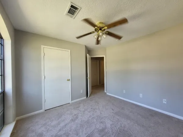 a view of a big room with a chandelier fan and closet area