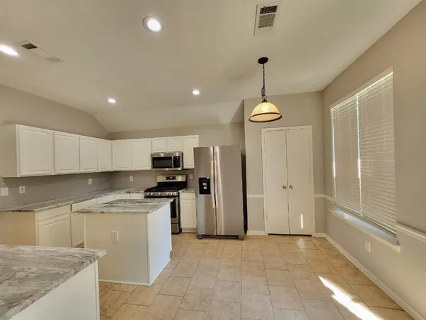 a kitchen with kitchen island a sink stainless steel appliances and cabinets