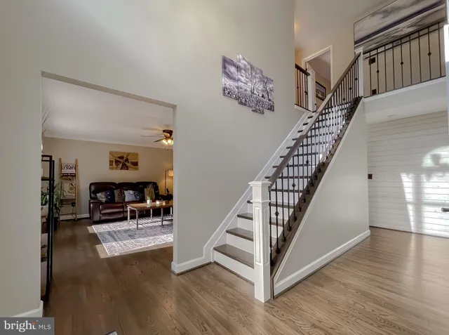 a dining room with wooden floor a chandelier a wooden table and chairs