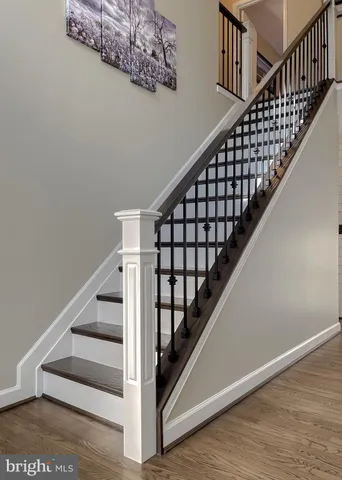 a living room with stainless steel appliances furniture a rug and a kitchen view