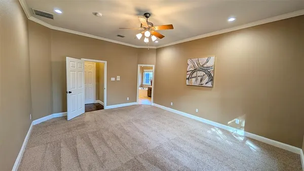 a view of an empty room with a chandelier fan