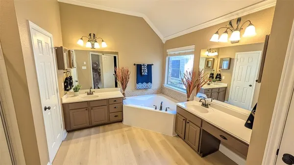 a spacious bathroom with a tub sink and mirror
