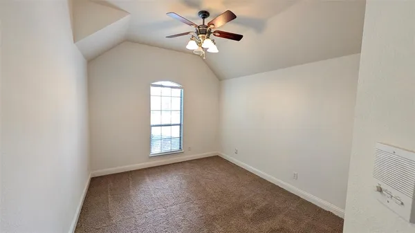 an empty room with windows and fan