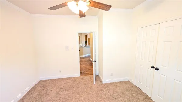 an empty room with a ceiling fan and a window