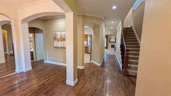 a view of a hallway with wooden floor and staircase
