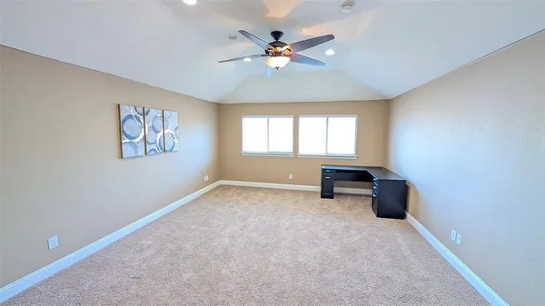 an empty room with windows and ceiling fan