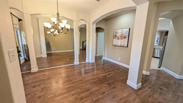 a view of a livingroom with wooden floor and stairs