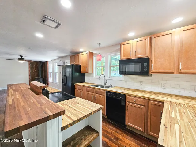 a kitchen with a sink a counter top space stainless steel appliances and cabinets