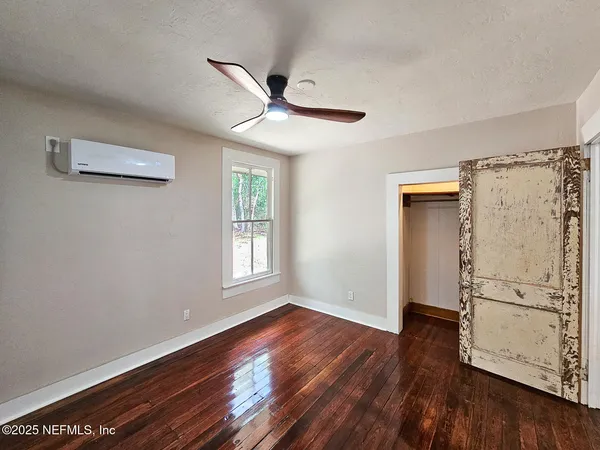 a view of empty room with wooden floor and window