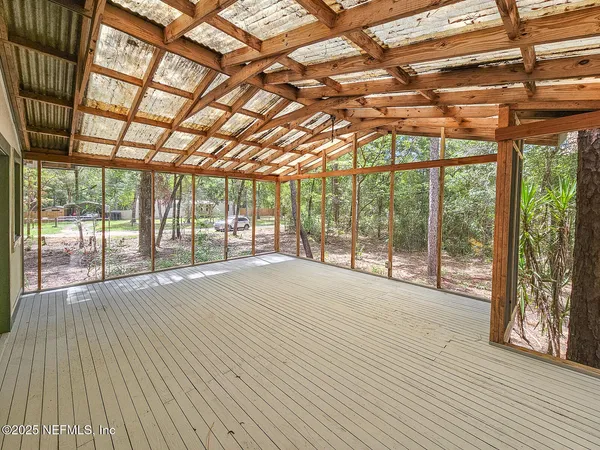 a view of an empty room with wooden floor and a iron gate