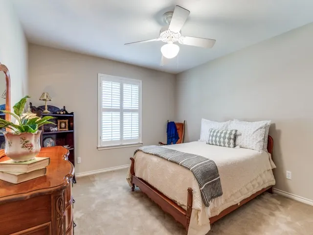a bedroom with a bed table and a window
