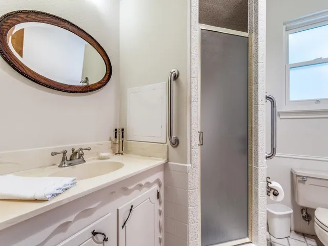 a bathroom with a granite countertop toilet sink and mirror