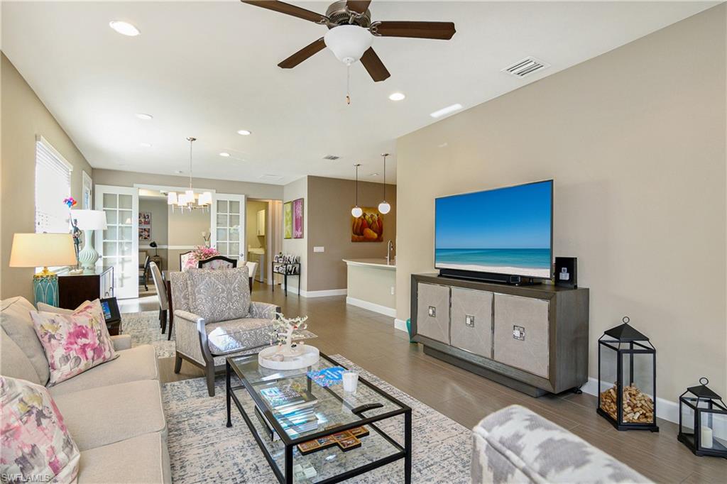 20111 Torch Key Way Estero, FL 33928 - Photo 12 of 29 a living room with furniture a flat screen tv and a chandelier