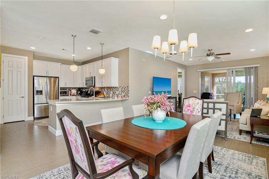 20111 Torch Key Way Estero, FL 33928 - Photo 2 of 29 a dining room with stainless steel appliances kitchen island a table and chairs