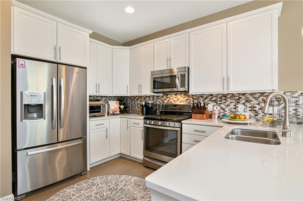 20111 Torch Key Way Estero, FL 33928 - Photo 4 of 29 a kitchen with stainless steel appliances a refrigerator sink and microwave