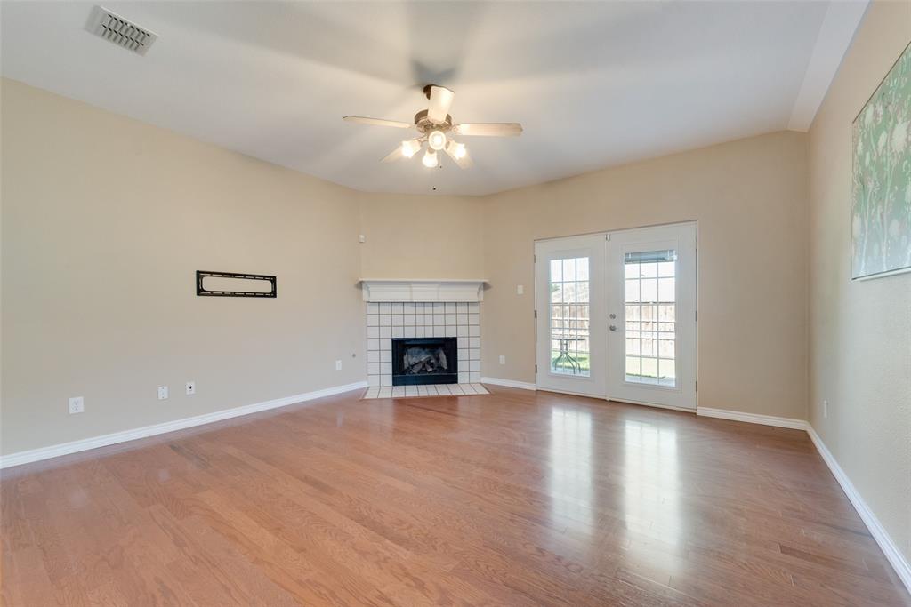 4512 Shade Tree Court Sachse, TX 75048 - Photo 3 of 19 an empty room with wooden floor fireplace and windows