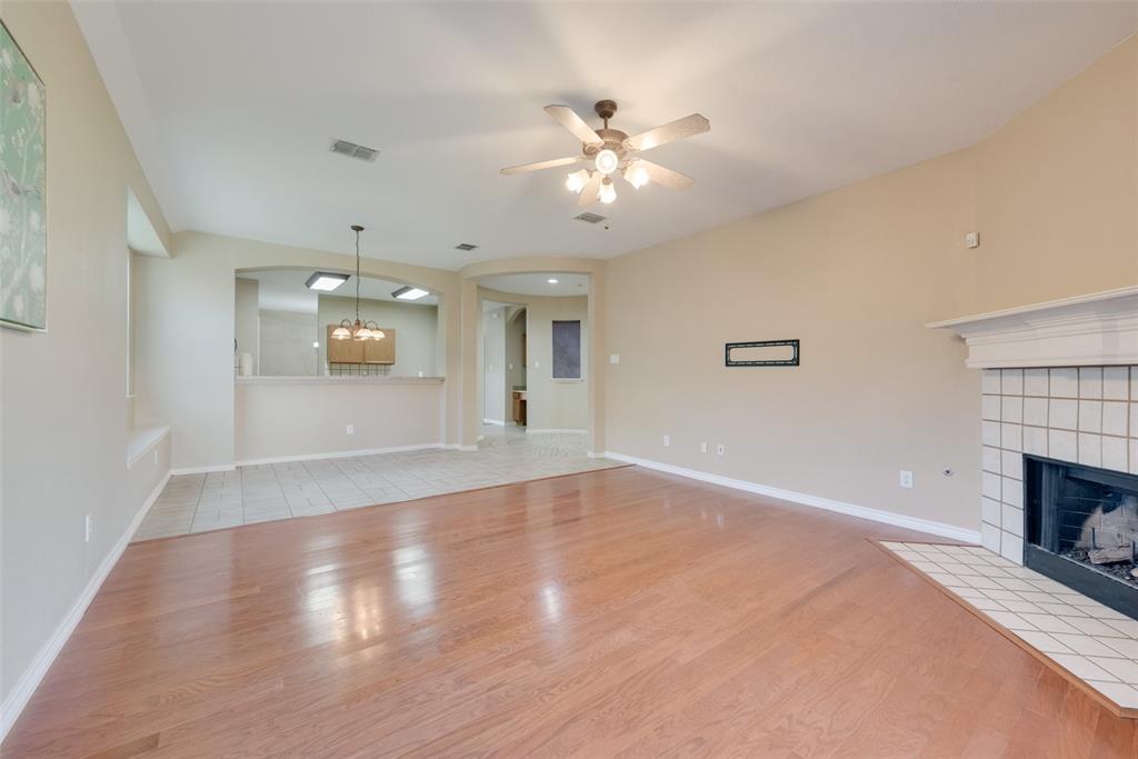 4512 Shade Tree Court Sachse, TX 75048 - Photo 4 of 19 a view of an empty room with wooden floor and fireplace