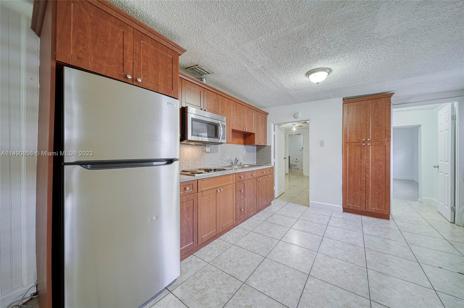 6534 Southwest 34th Street, Unit 2 Miami, FL 33155 - Photo 9 of 20 a kitchen with stainless steel appliances granite countertop a refrigerator and a sink