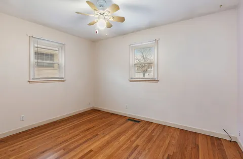 an empty room with a window and wooden floor