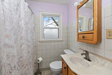 a bathroom with a toilet sink vanity and mirror