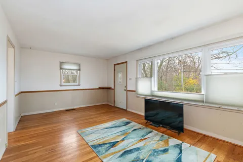 a kitchen with stainless steel appliances granite countertop a sink a stove a refrigerator cabinets and a dining table